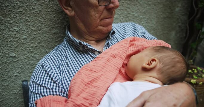Grandfather with baby grandchild in yard