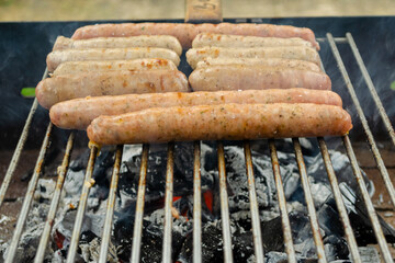 Aromatic pork sausages are fried over charcoal. BBQ sausages on the grill. Cooking in nature