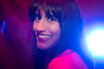 
beautiful young woman smiling with disco lighting