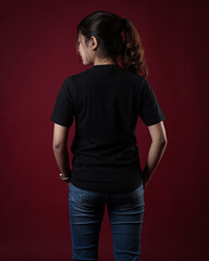 Front view black t-shirt Closeup on female body, woman girl in empty black t-shirt isolated on red background. Design woman t-shirt template and mockup for print.