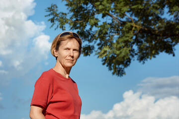 A portrait of a middle-aged woman in a red summer T-shirt.