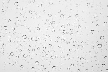 water droplets on car glass during raining / closeup of clear raindrops on glass surface