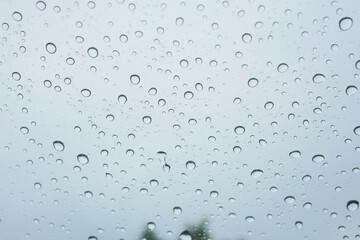 water droplets on car glass during raining / closeup of clear raindrops on glass surface