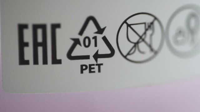 Macro view of eco labeling and recycling marks on product packaging spbd. Moving shot of symbols and letters on white background. Figure helps to understand what kind of packaging it is and whether it