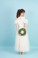 クリスマスリースを手に持つ女性