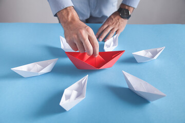 Businessman holding red origami paper boat. White boats. Business, Leadership
