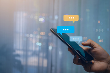 Person hand use smartphone typing, chatting conversation in chat bubble pop-up. Social media maketing concept.