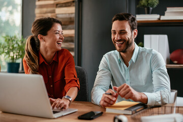 Colleagues in office. Businesswoman and businessman discussing work in office. Two friends in working together.	