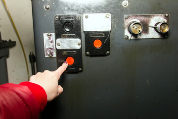 hand presses the start button at the factory