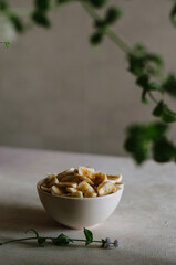 Pretty small bowl with sliced banana on table in the kitchen with mint leaves decoration. Tasty and healthy vegetarian food 