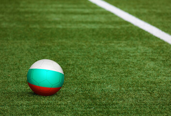 Bulgaria flag on ball at soccer field background. National football theme on green grass. Sports competition concept.
