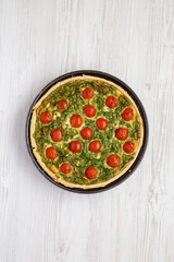 Homemade Spinach Quiche in a baking dish on a white wooden background, top view. Flat lay, overhead, from above.