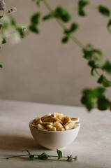 Pretty small ivory bowl with sliced banana on table in the kitchen with mint leaves decoration. Tasty and healthy vegetarian food isolated close up