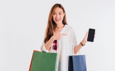 Asian beautiful women blogger are using the smartphone shopping online with a shopping bag in white color background with copy space.Concept of online shopping business with Promotion and Sale.