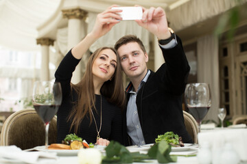 Beautiful couple taking selfie photo in a restaurant