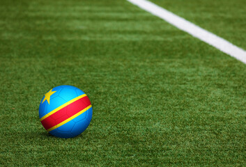 Plakat Congo flag on ball at soccer field background. National football theme on green grass. Sports competition concept.