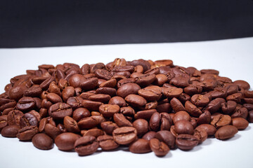 beautiful coffee beans sprinkled on a white table with a black background