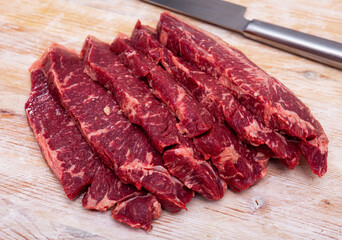 Obraz premium Raw juicy marbled beef entrecotes on wooden surface. Traditional deli meats