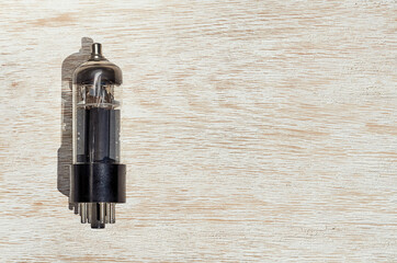 small vacuum glass electronic retro light bulb on the wooden background
