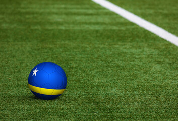 Plakat Curacao flag on ball at soccer field background. National football theme on green grass. Sports competition concept.