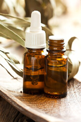 Eucalyptus essential oil and  eucalyptus leaves on wooden table