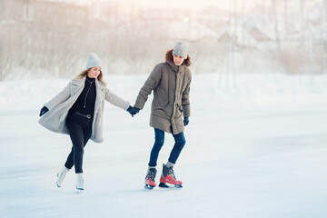 Fototapeta na wymiar Ice skating lover couple having fun on snow winter holidays