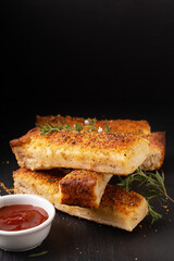 Food appetizer ideas for party concept homemade organic garlic bread stick on black slate board with copy space