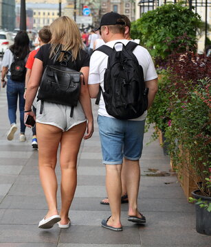 A girl in short knitted shorts with a guy, the embankment of the Griboyedov canal. Saint Petersburg, Russia July 2020