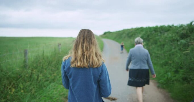 Young woman walking with her mother in the countryside