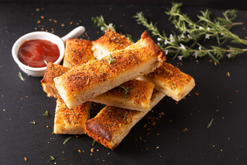 Food appetizer ideas for party concept homemade organic garlic bread stick on black slate board...