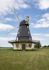 old wind mill in denmark with a field