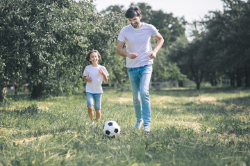 Dark-haired boy and his father playing with the ball