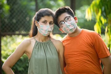Fototapeta premium Mother and son with protective face mask looking at camera