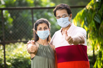 Couple with protective face mask at park