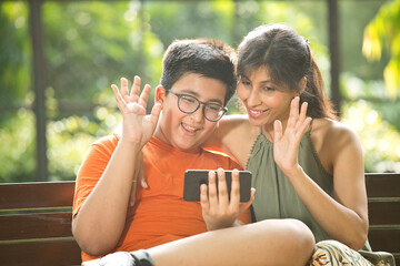 Mother and son using mobile phone for video call