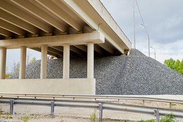Bottom view of the prestressed concrete beams and piers of bridge crossing many-lane expressway of...