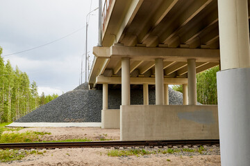 Fototapeta premium Bottom view of the prestressed concrete beams and piers of bridge crossing many-lane expressway of road.