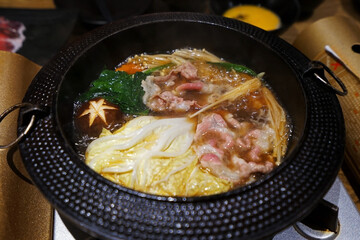 Close up beef and pork meat with mixed vegetables in Sukiyaki pan, Japanese hot pot