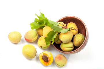 Fresh ripe apricots in wooden bowl isolated on a white background.