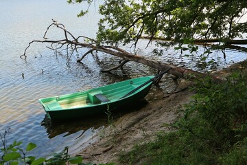 Naklejka na ściany i meble Boat moored at the shore of the lake