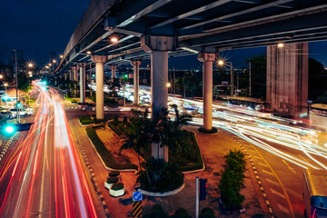 Fototapeta na wymiar Car lights at evening on the road going to the city. Aerial view of the speed traffic trails on motorway highway in Yannawa, Rama 3, Bangkok, Thailand. Long exposure abstract.