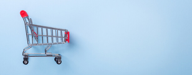 Mini trolley cart copy on blue background. Horizontal banner. Top view Copy space