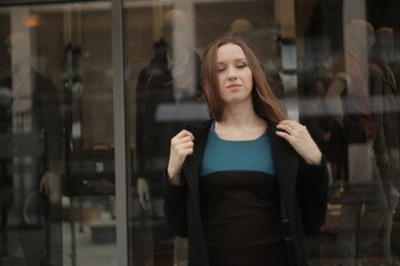 The girl in black coat. Beautiful emotional young girl in the city. Shawl or handkerchief on a person. 