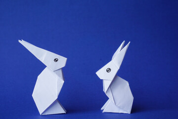 Simple flat lay out. two White rabbits paper origami on clear background with copy space concept