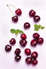 Berries of cherry on pink background. Mint leaves