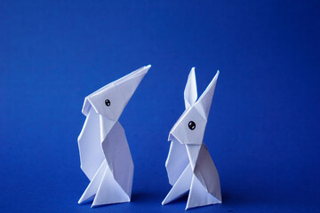 Simple flat lay out. two White rabbits paper origami on clear background with copy space concept