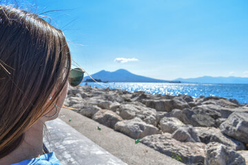 Fototapeta na wymiar Girl from behind, looking at the Vesuvius in Naples
