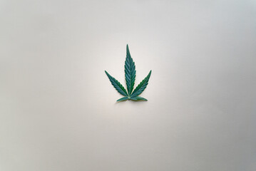 green cannabis leaf on white background