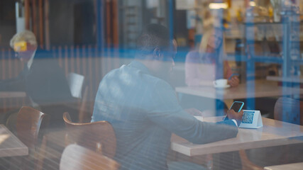 Handsome african businessman scan barcode in restaurant to get discount.