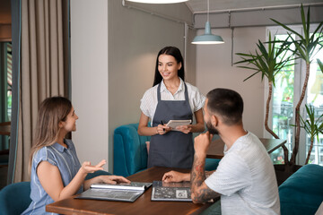 Waitress serving clients in restaurant